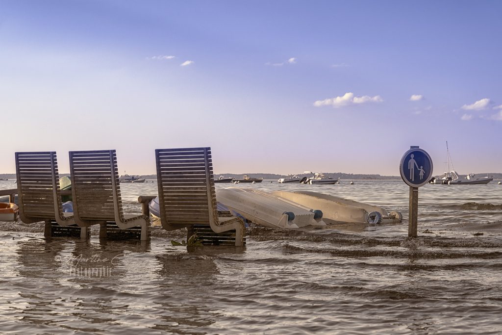 Bancs les pieds dans l'eau sur la promenade d'Arcachon aux grandes marées