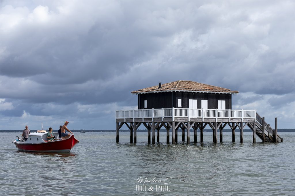 Cabane Tchanquée 53 et pinasse rouge sur le Bassin d'Arcachon
