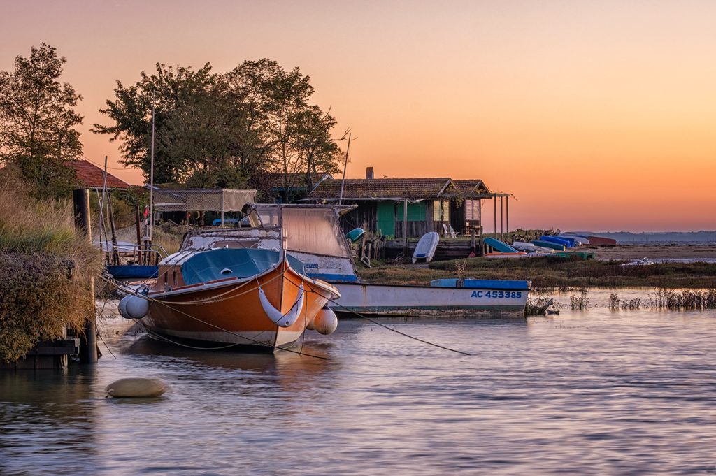Pinasse orange au lever du soleil à l'Aiguillon, Arcachon