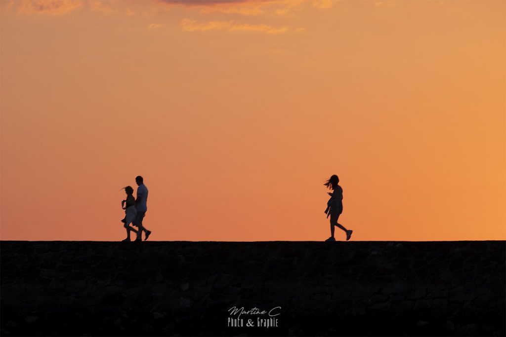 Silhouettes de promeneurs au coucher du soleil, port d'Arcachon