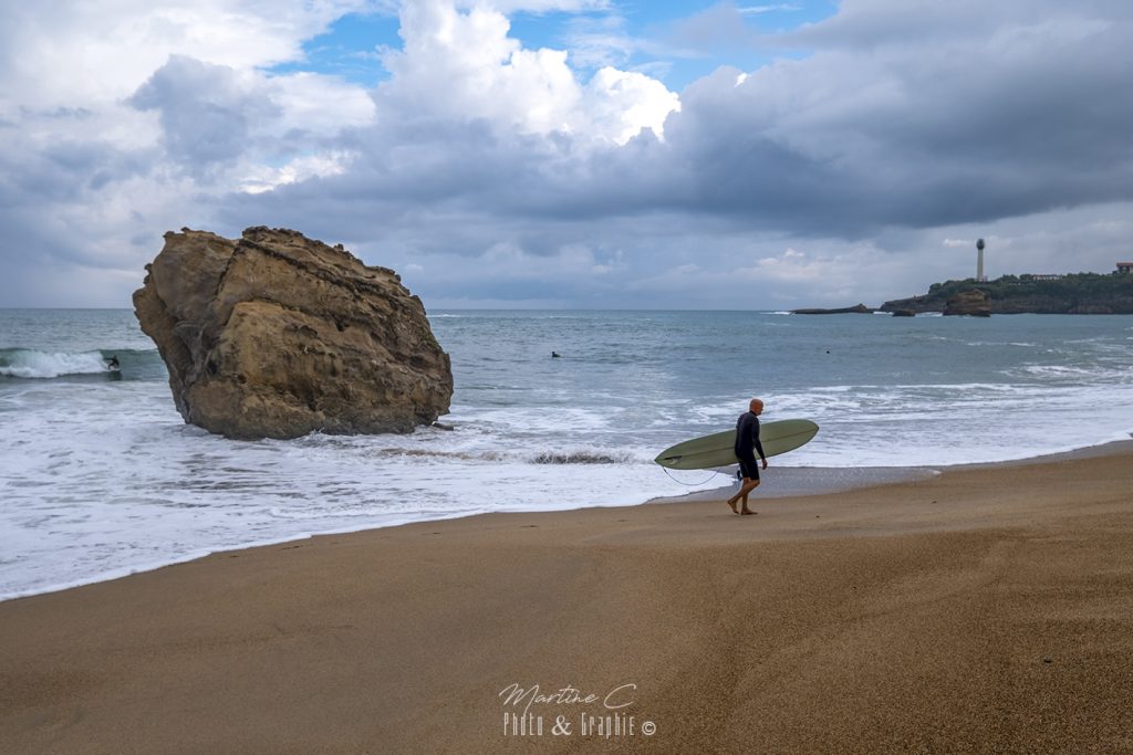 Surfeur sur la Grande Plage de Biarritz, phare au loin
