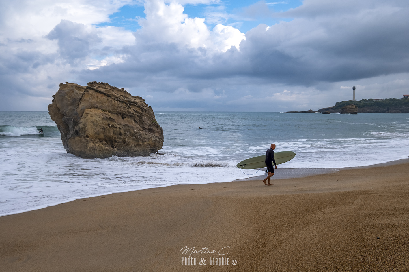 Surfeur sur la Grande Plage de Biarritz, phare au loin